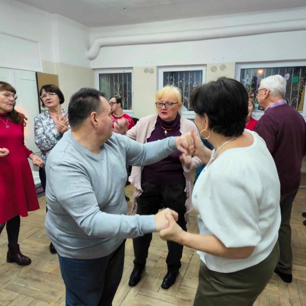 Para tańczy w otoczeniu grupy osób.